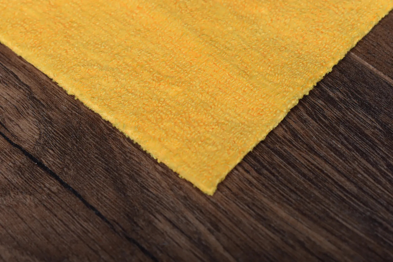 The Daily golden yellow microfiber towel close-up showing terry weave texture and edgeless construction