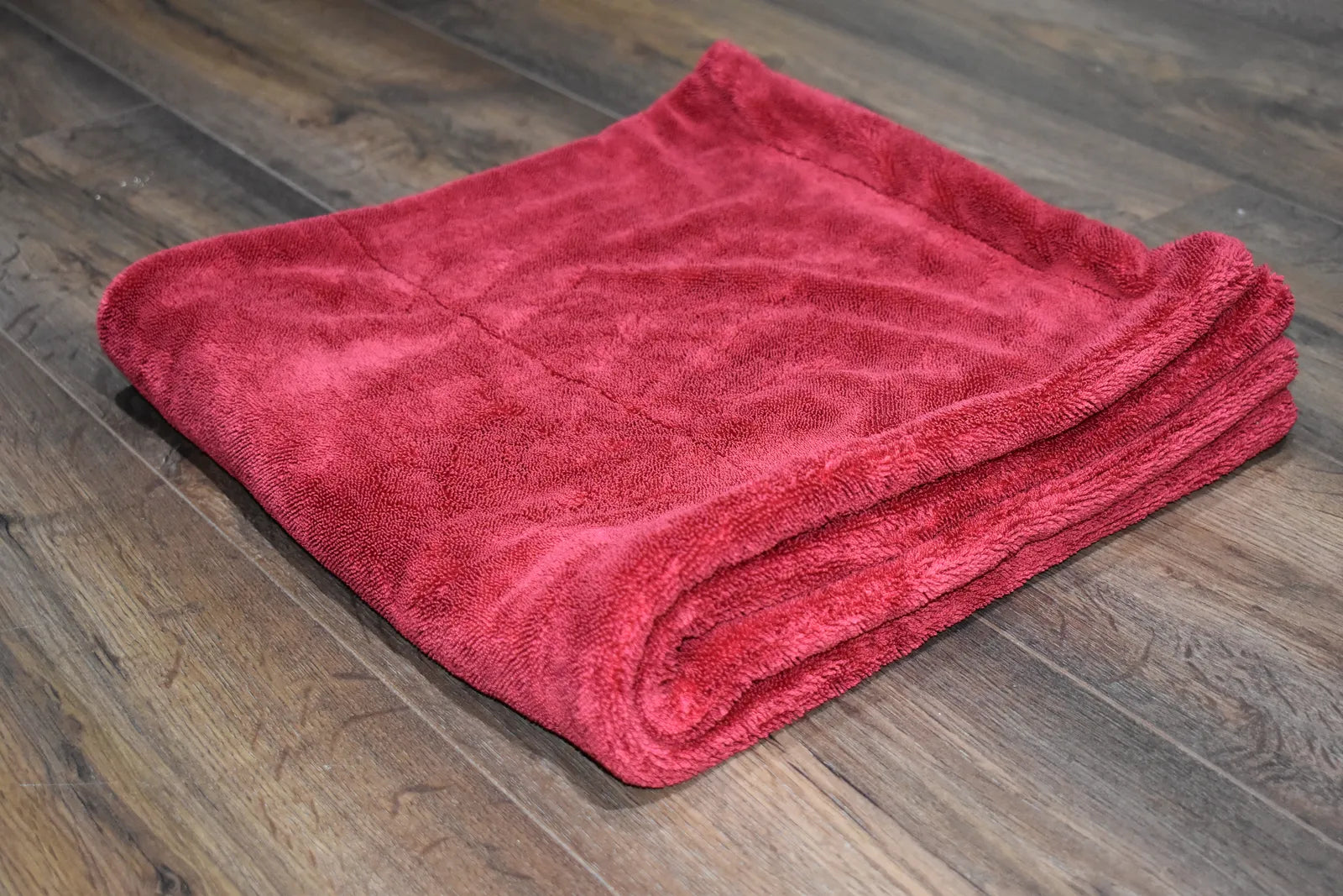 1500 GSM microfiber drying towel folded showing 76x76 cm square format and hemmed edge construction - color red