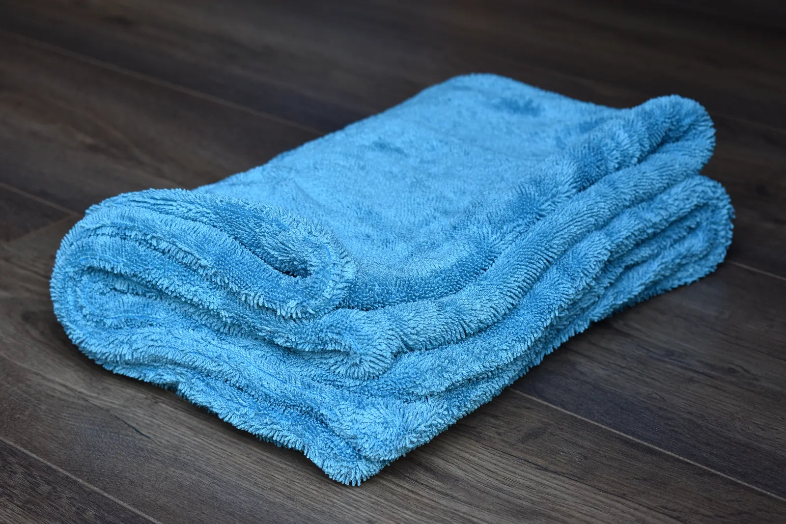 1100 GSM dual-layer microfiber drying towel angled view - aqua blue side showing twist-loop pile depth