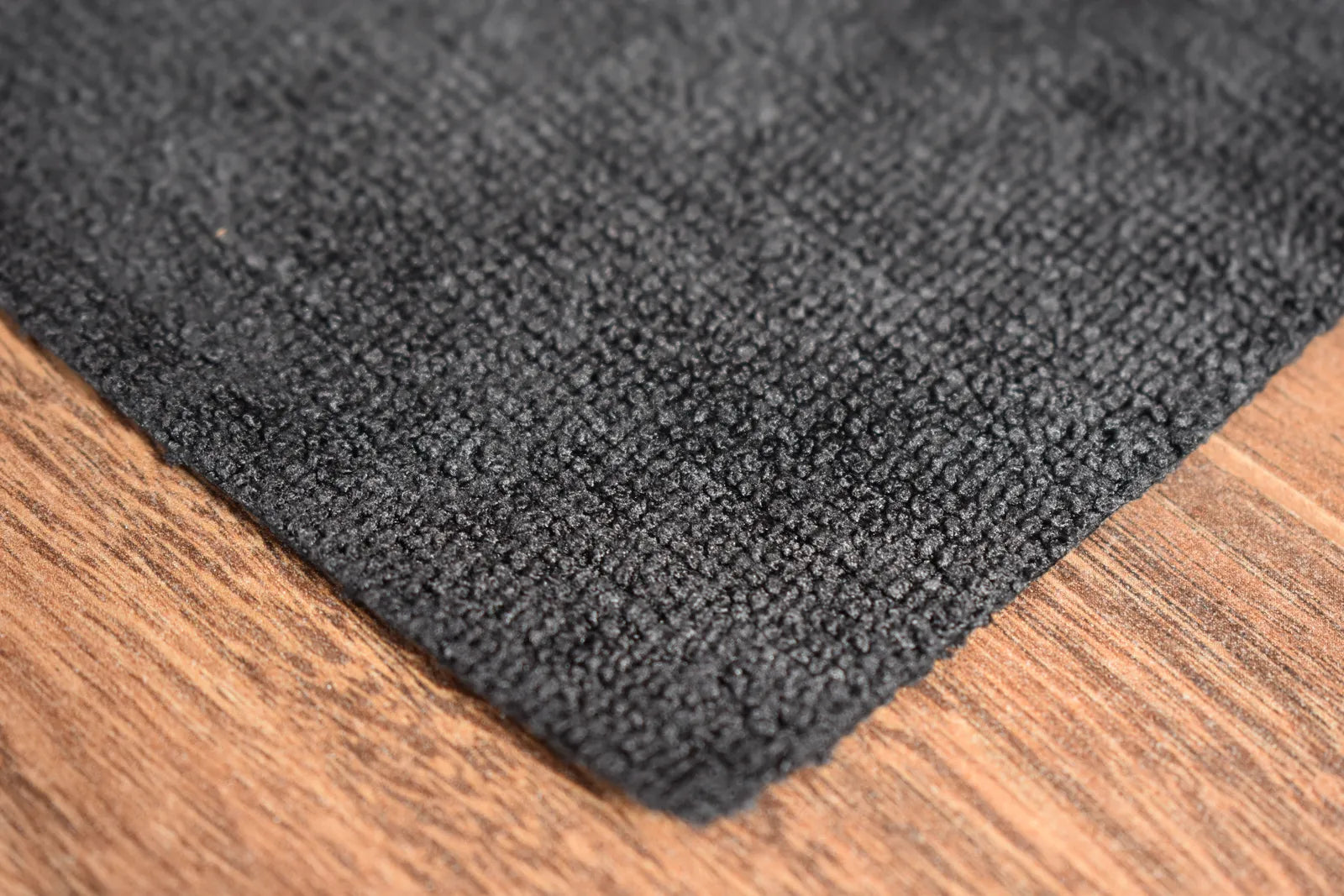 Light Terry black microfiber towel close-up showing terry weave texture and edgeless edge