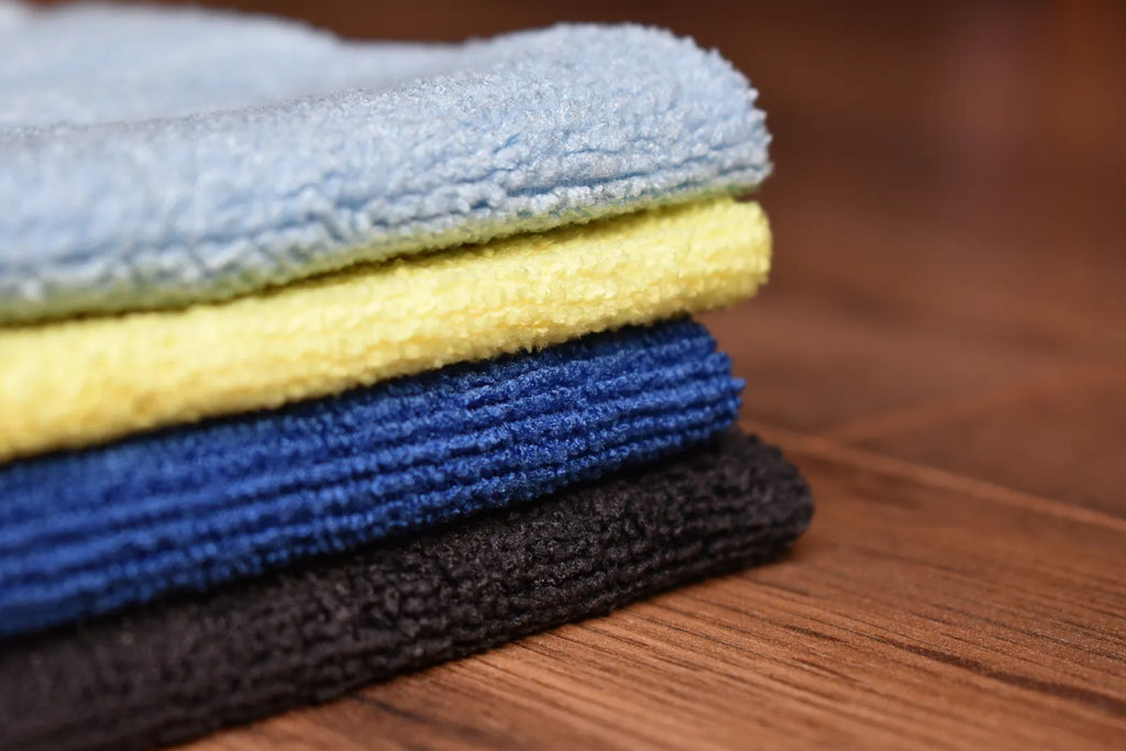 KHEMIA PLUS Light Terry 245 GSM edgeless microfiber towels stacked - blue, yellow, sky blue, and black colors showing terry weave texture